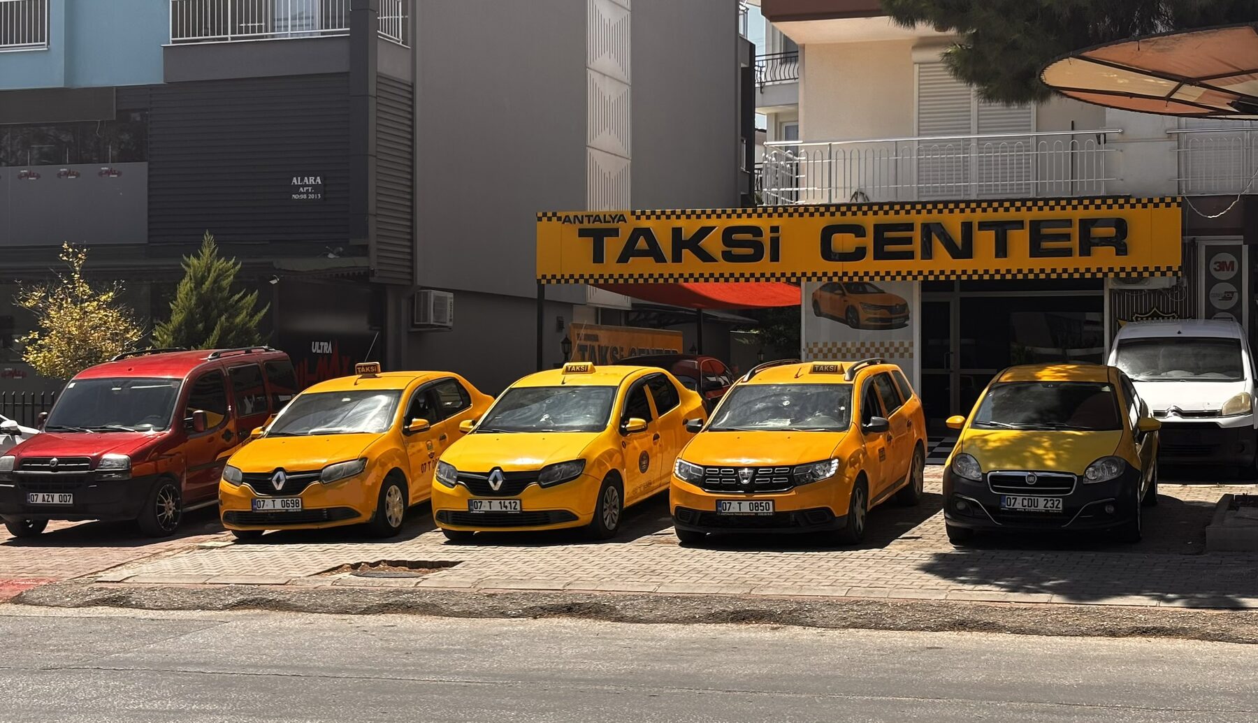 Antalya Taksi Center tabelası önünde sarı taksiler